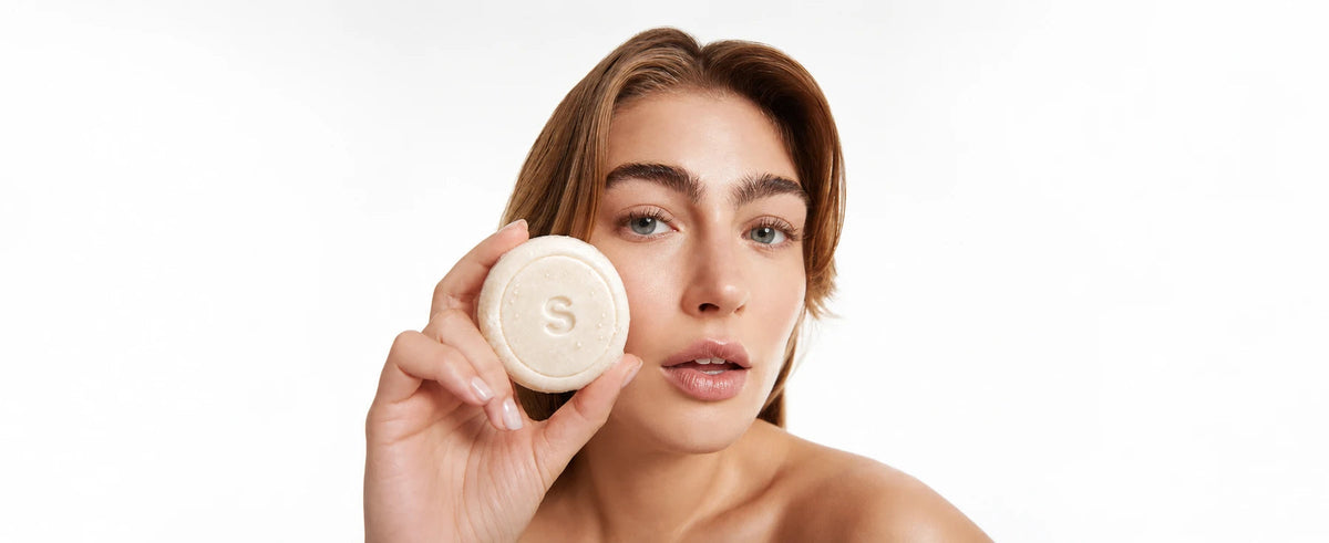 Woman with a luminous complexion holding the white SEYUN soap